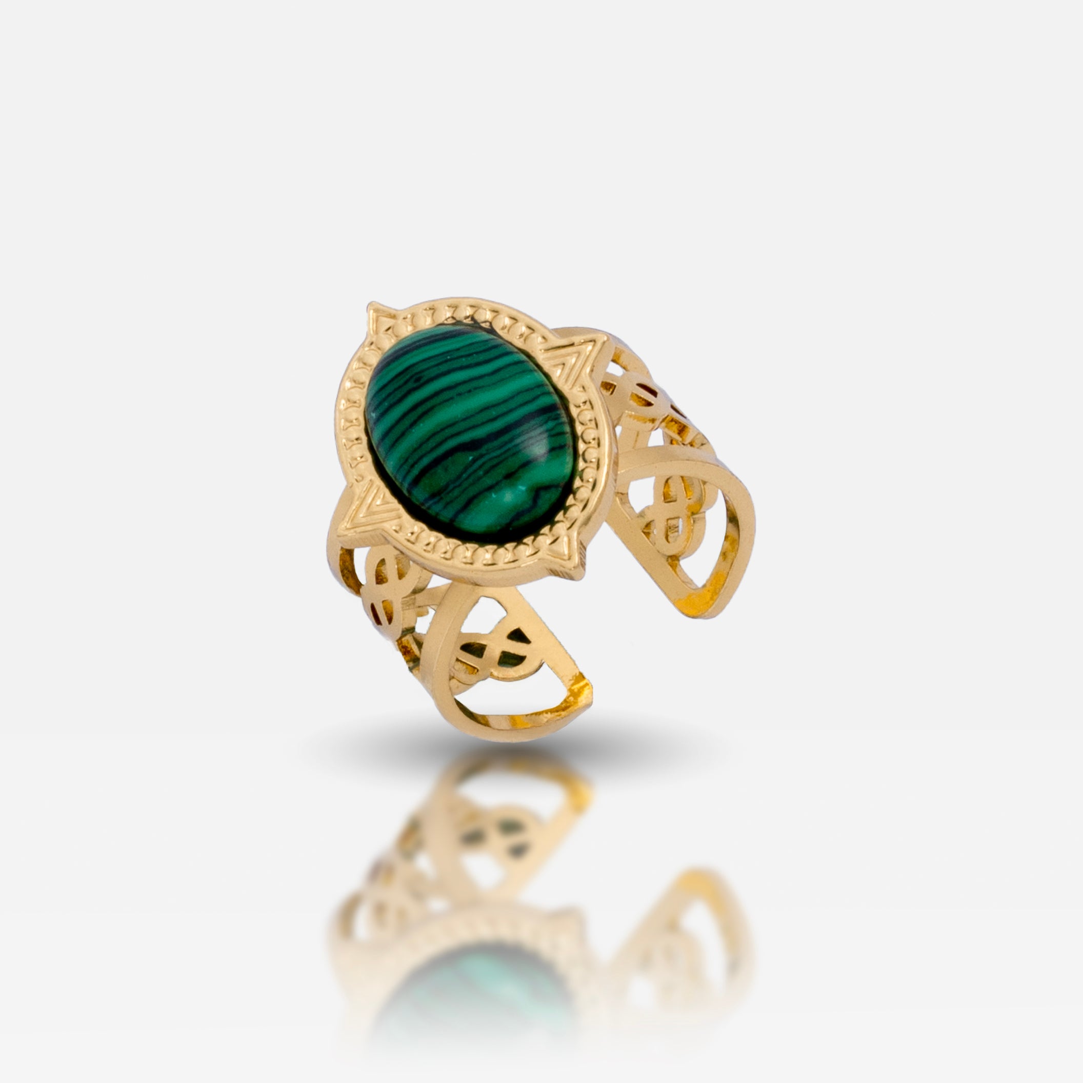 A gold-colored adjustable ring with a large green emerald-like stone in the center, surrounded by intricate detailing.